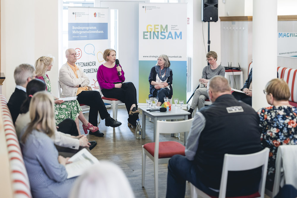 Bundesfamilienministerin Lisa Paus diskutiert mit einer Gruppe im Mehrgenerationenhaus