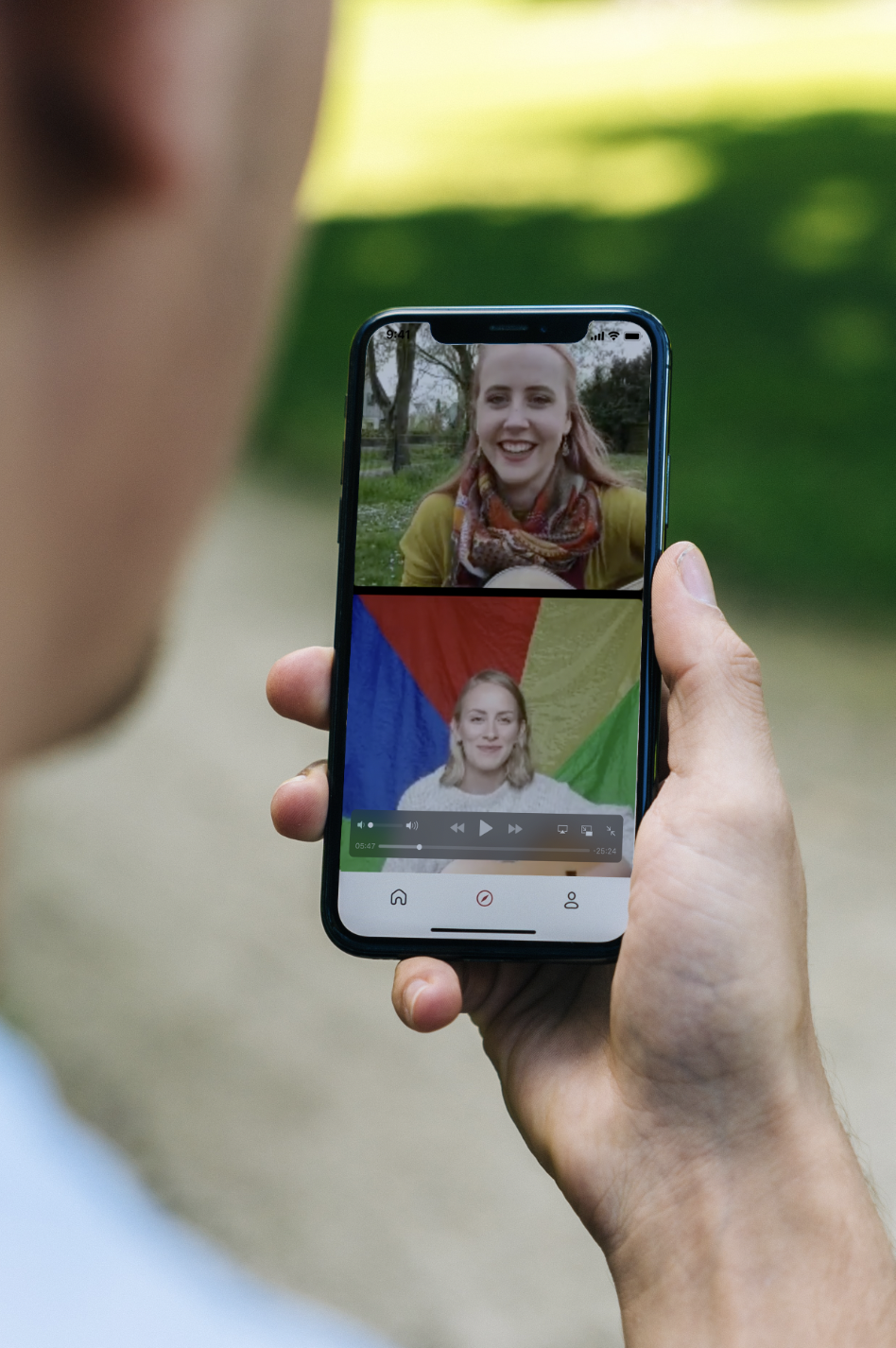 Hand hält Handy, auf dem der Live-Stream der Mehrgenerationenhäuser Fallbach und Casa zu sehen ist