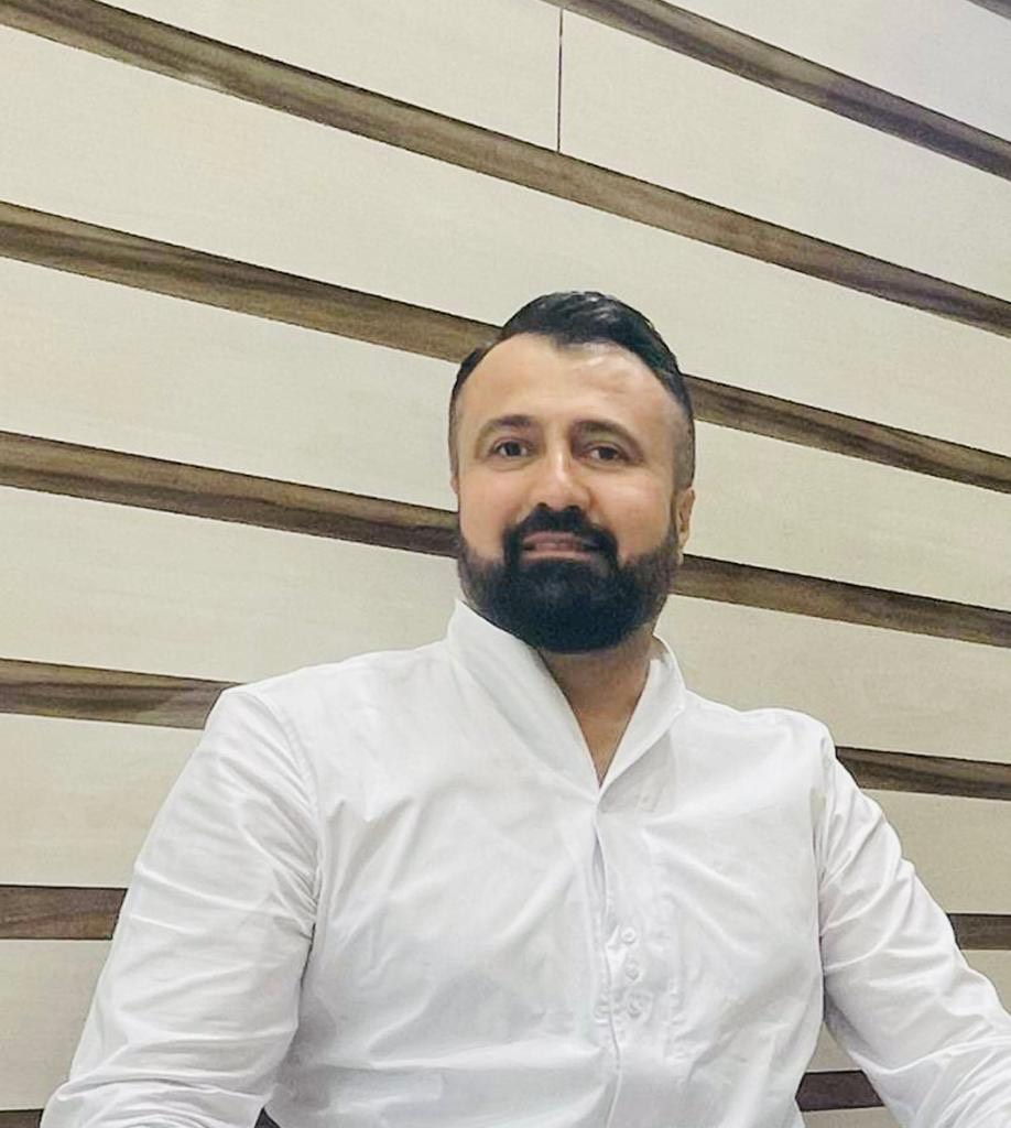 (c) Ahmed Saber Mahmud Porträtfoto von Ahmed Saber Mahmud, einem mit dunklen Haaren, Bart und einem weißen Hemd