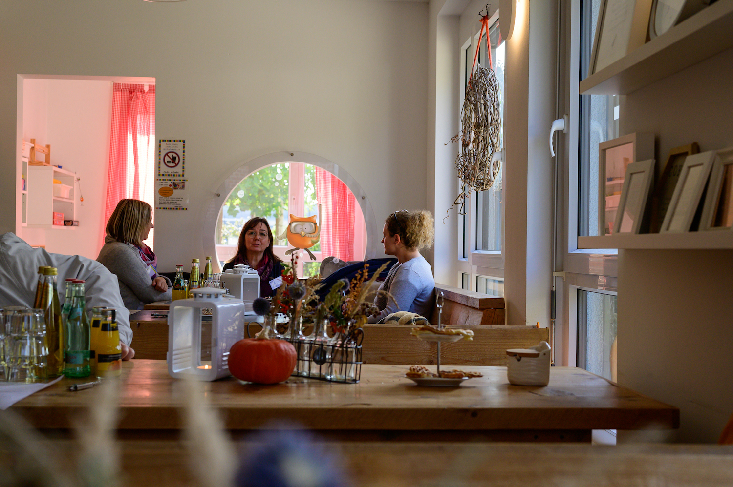 Drei Frauen sitzen an einem Tisch in einem Café und unterhalten sich