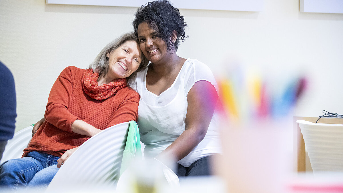 Zwei Frauen lehnen sich aneinander und lachen