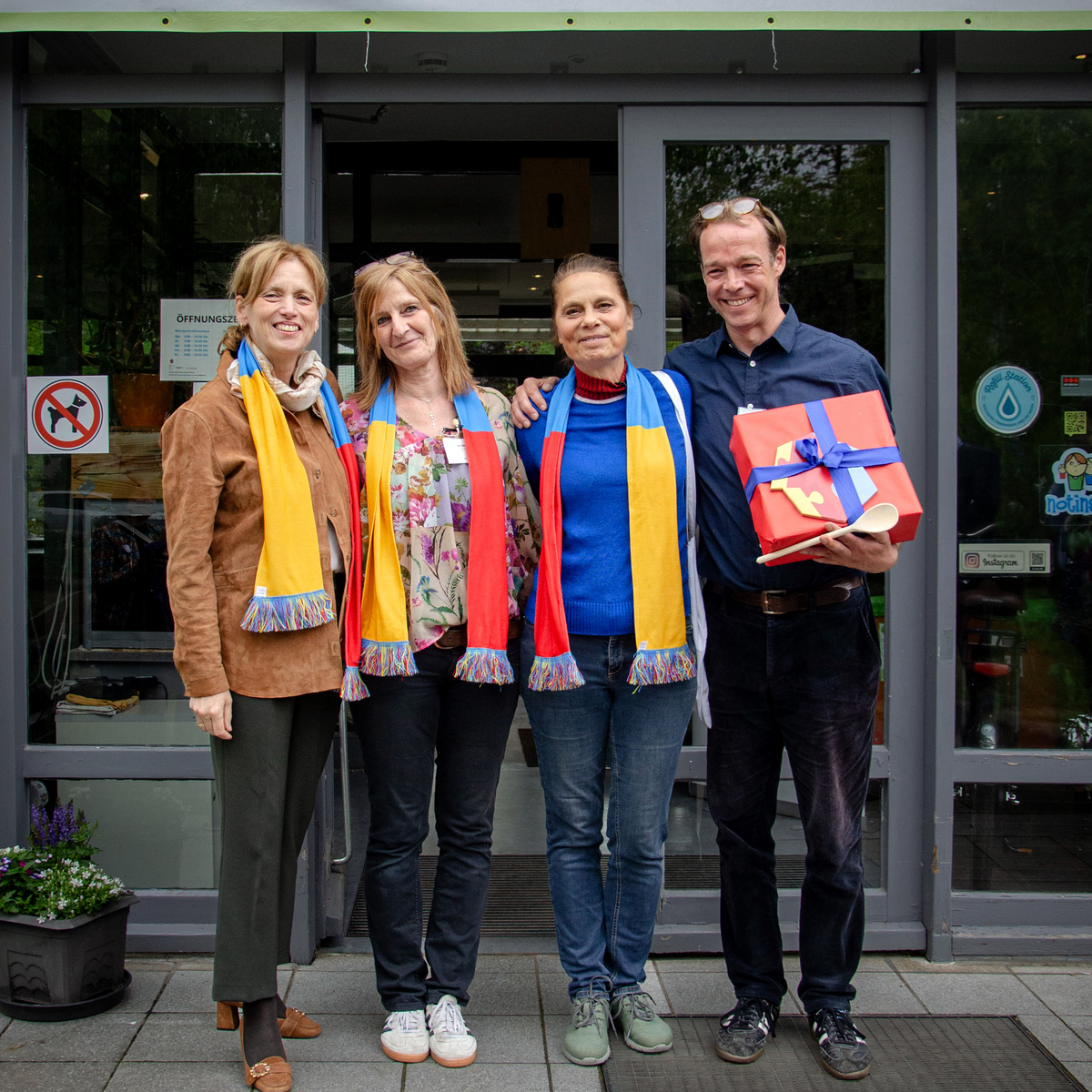 drei Frauen und ein Mann stehen vor dem Hauseingang vom Mehrgenerationenhaus Phoenix