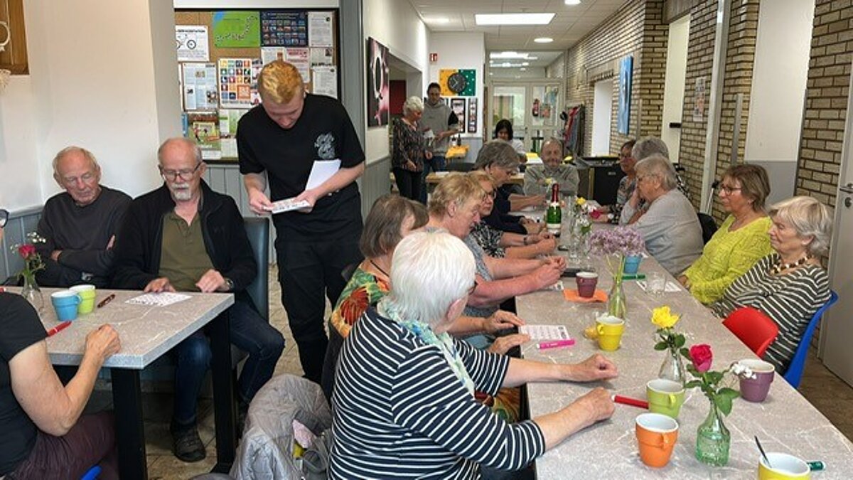  Besucher*innen warten auf das Austeilen der Bingokarten