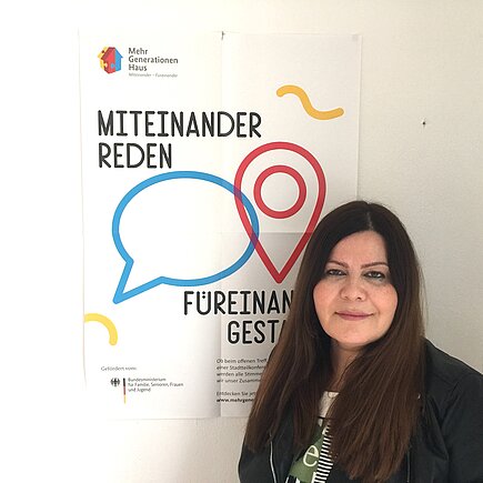 Farzaneh Motefaregheh neben einem MGH-Poster