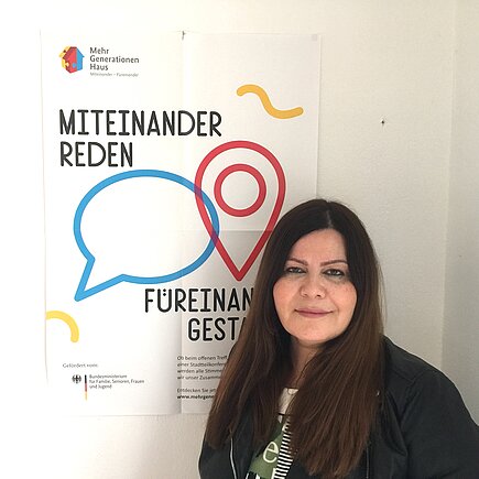 Farzaneh Motefaregheh neben einem MGH-Poster