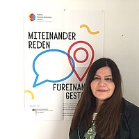 Farzaneh Motefaregheh neben einem MGH-Poster