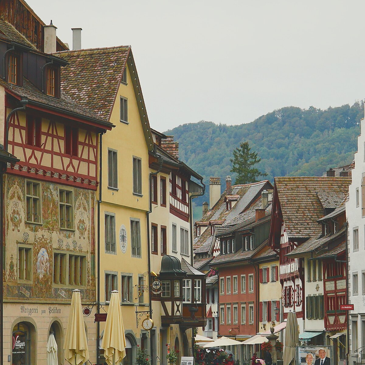 Aufnahme einer Altstadt mit Fachwerkhäusern, im Hintergrund sind Hügel zu sehen.