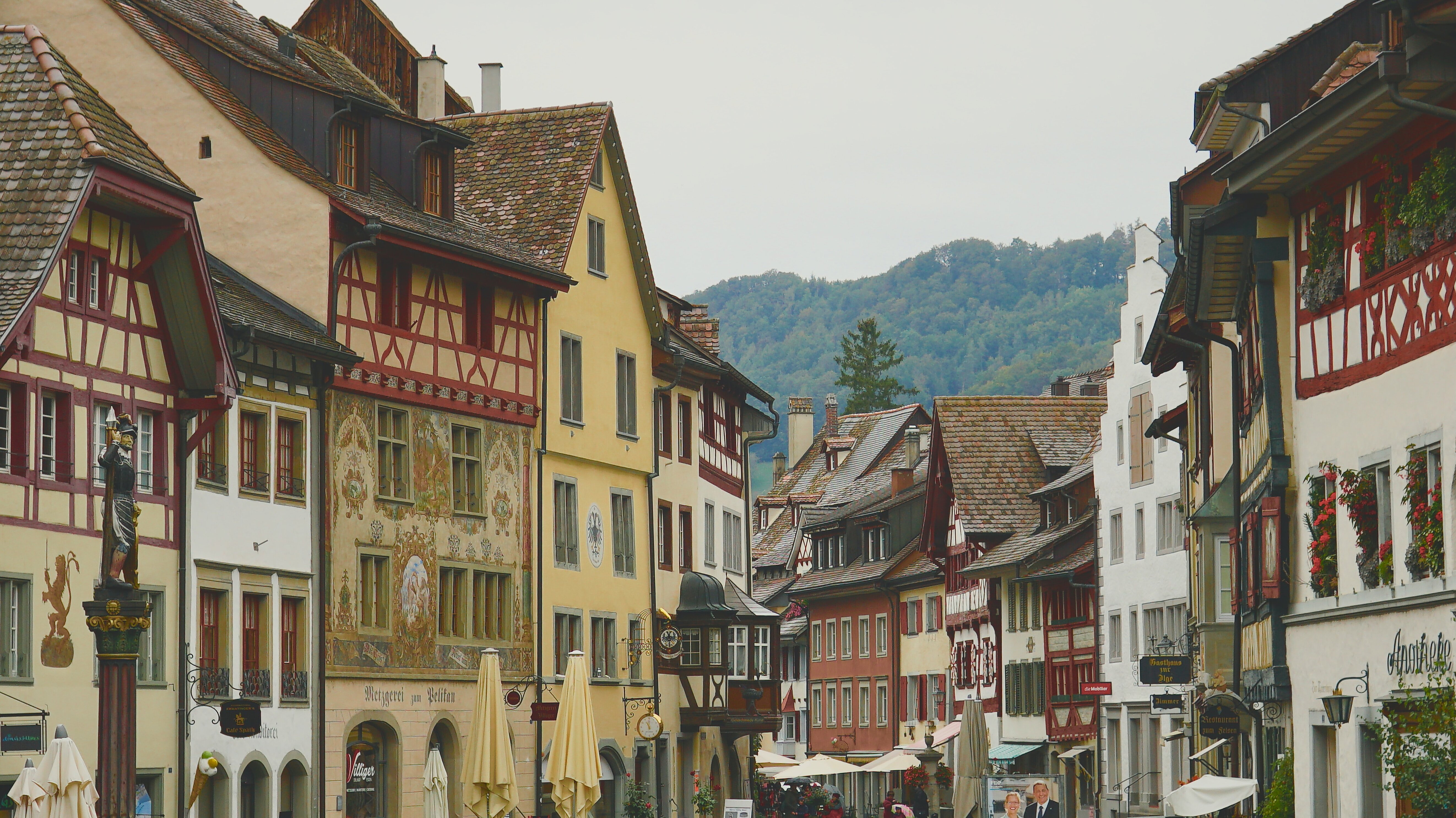 Aufnahme einer Altstadt mit Fachwerkhäusern, im Hintergrund sind Hügel zu sehen.