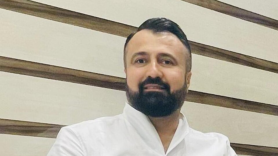 Porträtfoto von Ahmed Saber Mahmud, einem mit dunklen Haaren, Bart und einem weißen Hemd