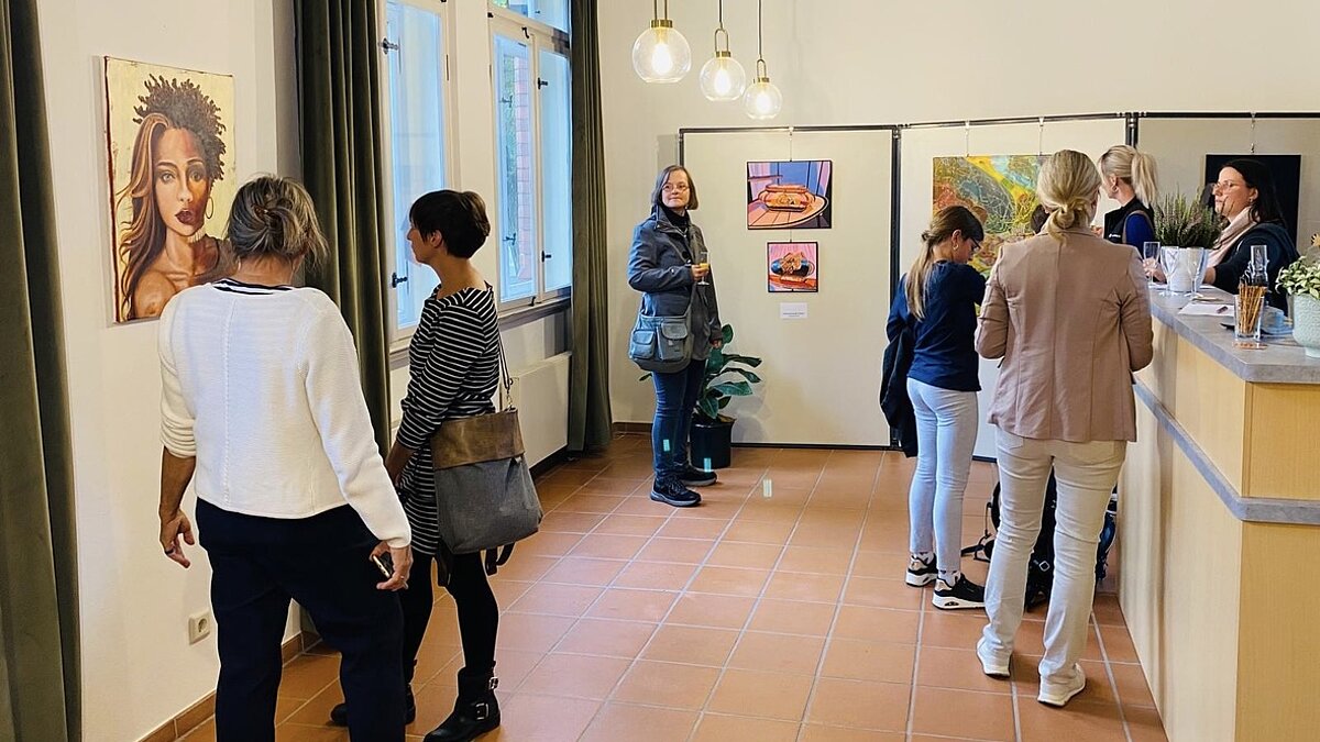 Mehrere Menschen schauen sich eine Kunstausstellung an