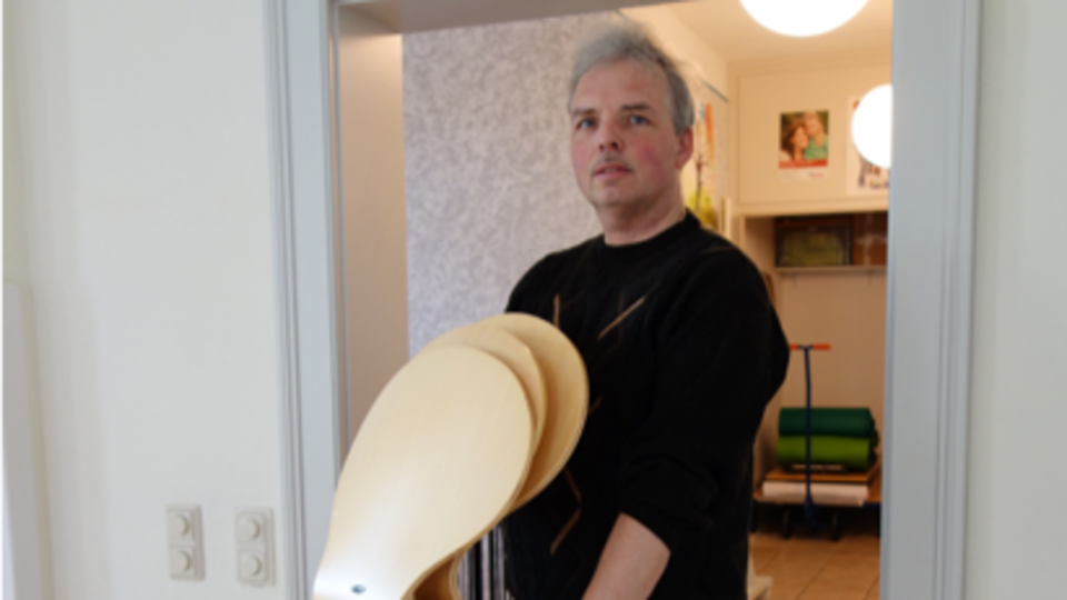 Thomas Hohl trägt einen Stapel Stühle