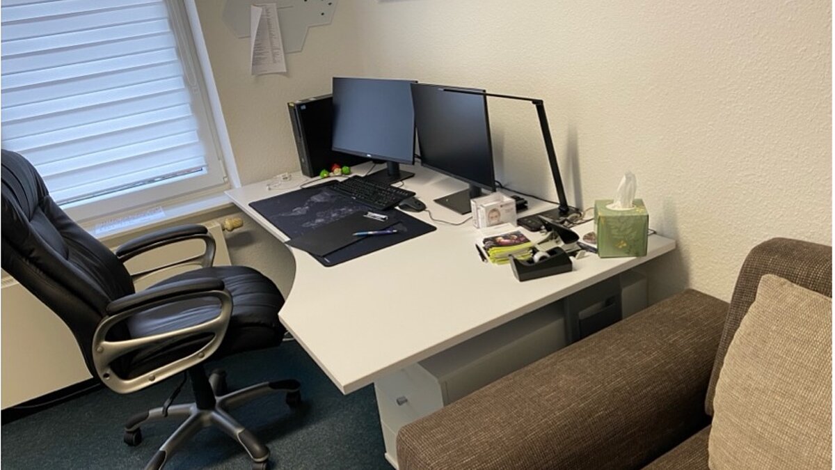 Ein Schreibtisch mit leerem Stuhl und Computer