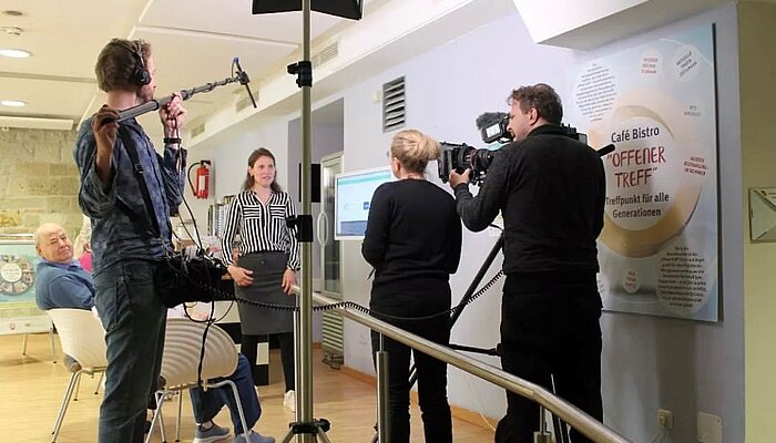 Ein Filmteam interviewt eine Frau. 