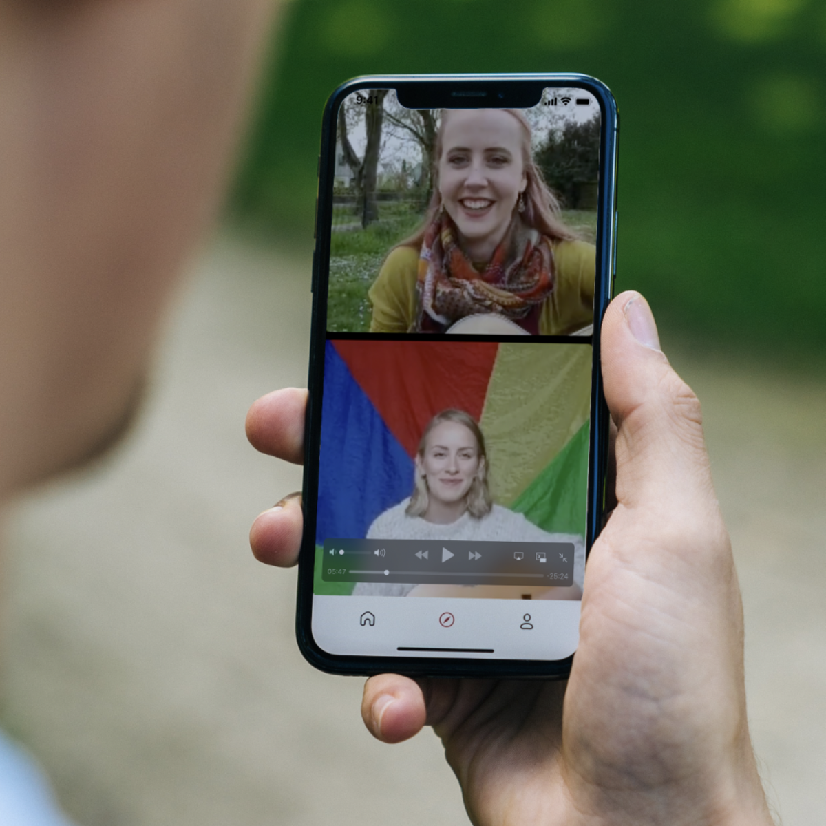 Hand hält Handy, auf dem der Live-Stream der Mehrgenerationenhäuser Fallbach und Casa zu sehen ist