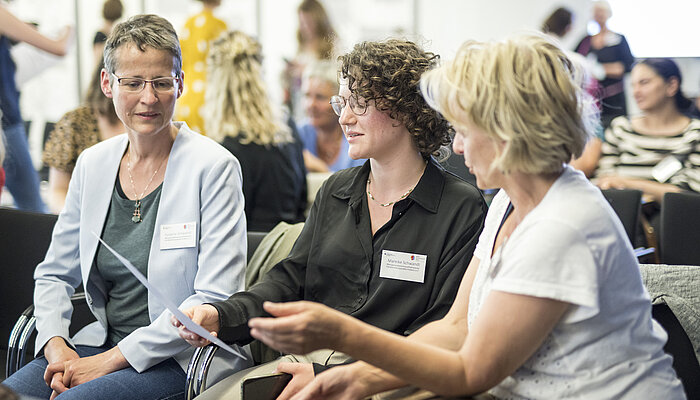 Drei Frauen unterhalten sich angeregt.