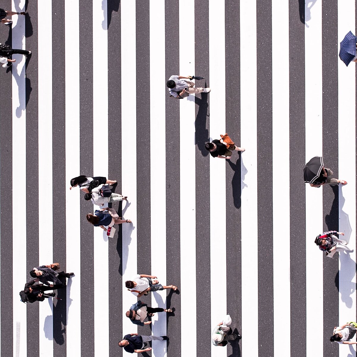 Menschen auf einem Zebrastreifen aus der Vogelperspektive fotografiert. 