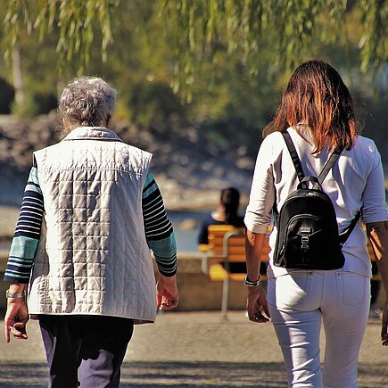 Jüngere und ältere Frau beim Spaziergang im Park