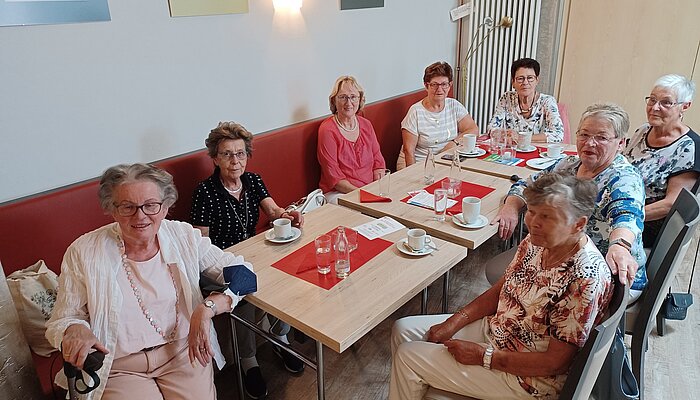 Acht ältere Damen sitzen an einem Tisch