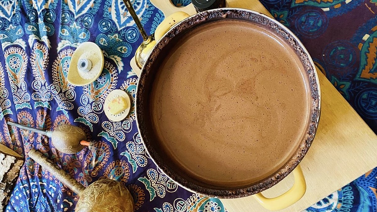 Eine Schüssel mit Cacao und Zubehör stehen auf einer bunten Decke.