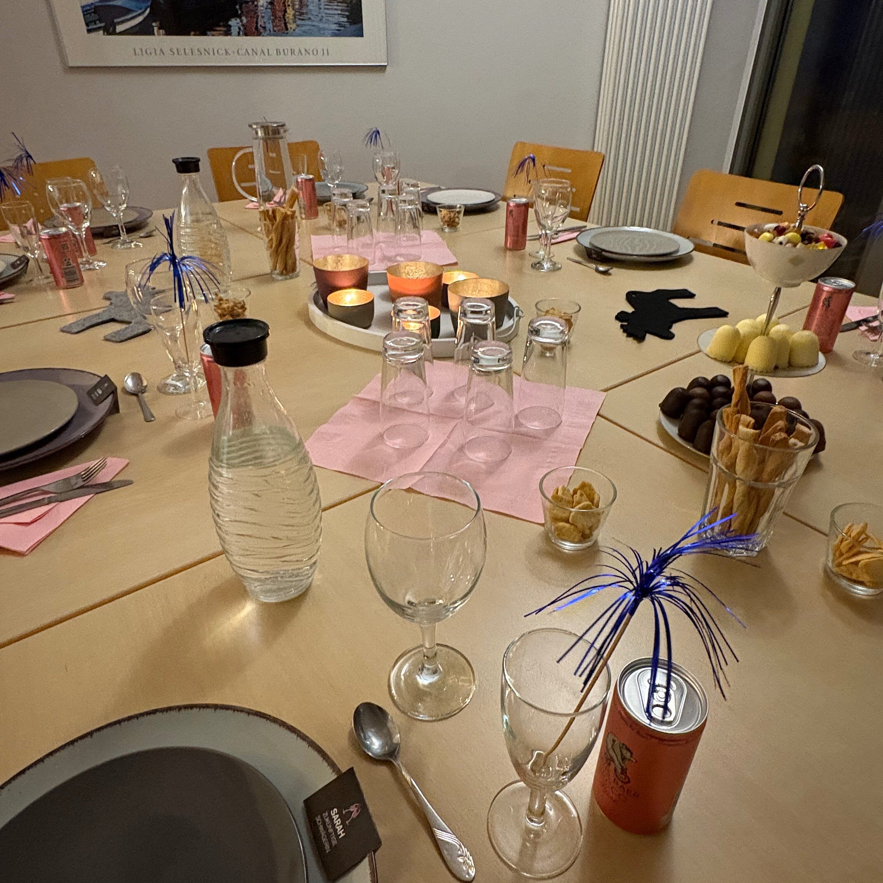 Ein gedeckter Tisch mit Tellern, Gläsern und bunter Dekoration