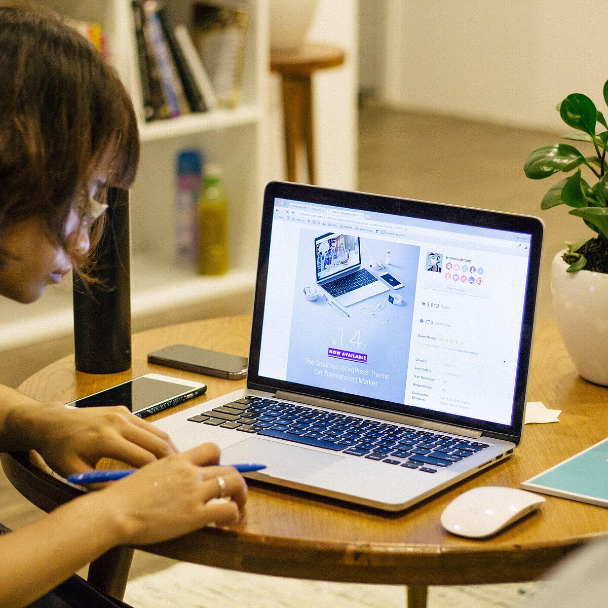 © Tran Mau Tri Tam / Unsplash Frau sitzt an einem runden Holztisch und arbeitet an einem Laptop.