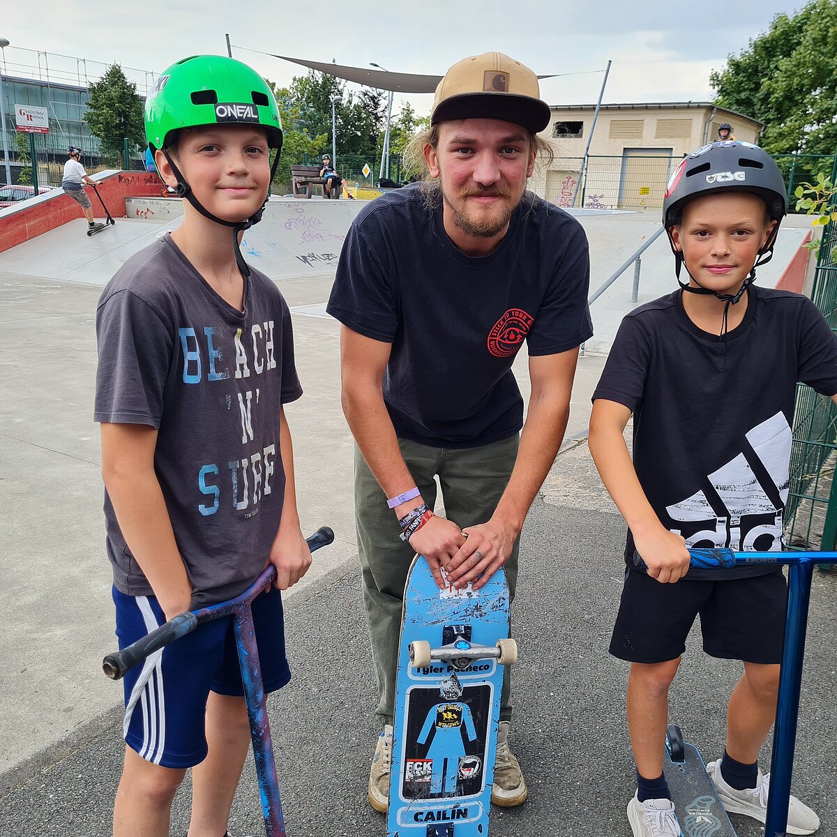 (c) MGH Zwönitz Drei Jungs tragen Helme, stehen auf ihren Rollern und lächeln.