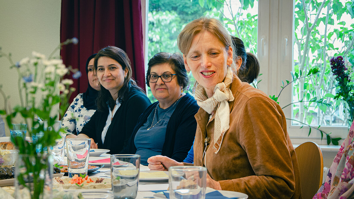 Bundesministerin Prien sitzt an einem Tisch und unterhält sich