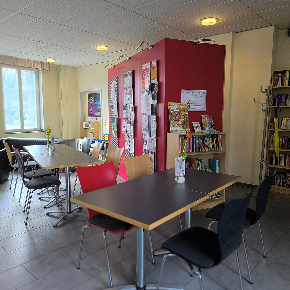 Infoboard und Bücherregale im Café CaTI