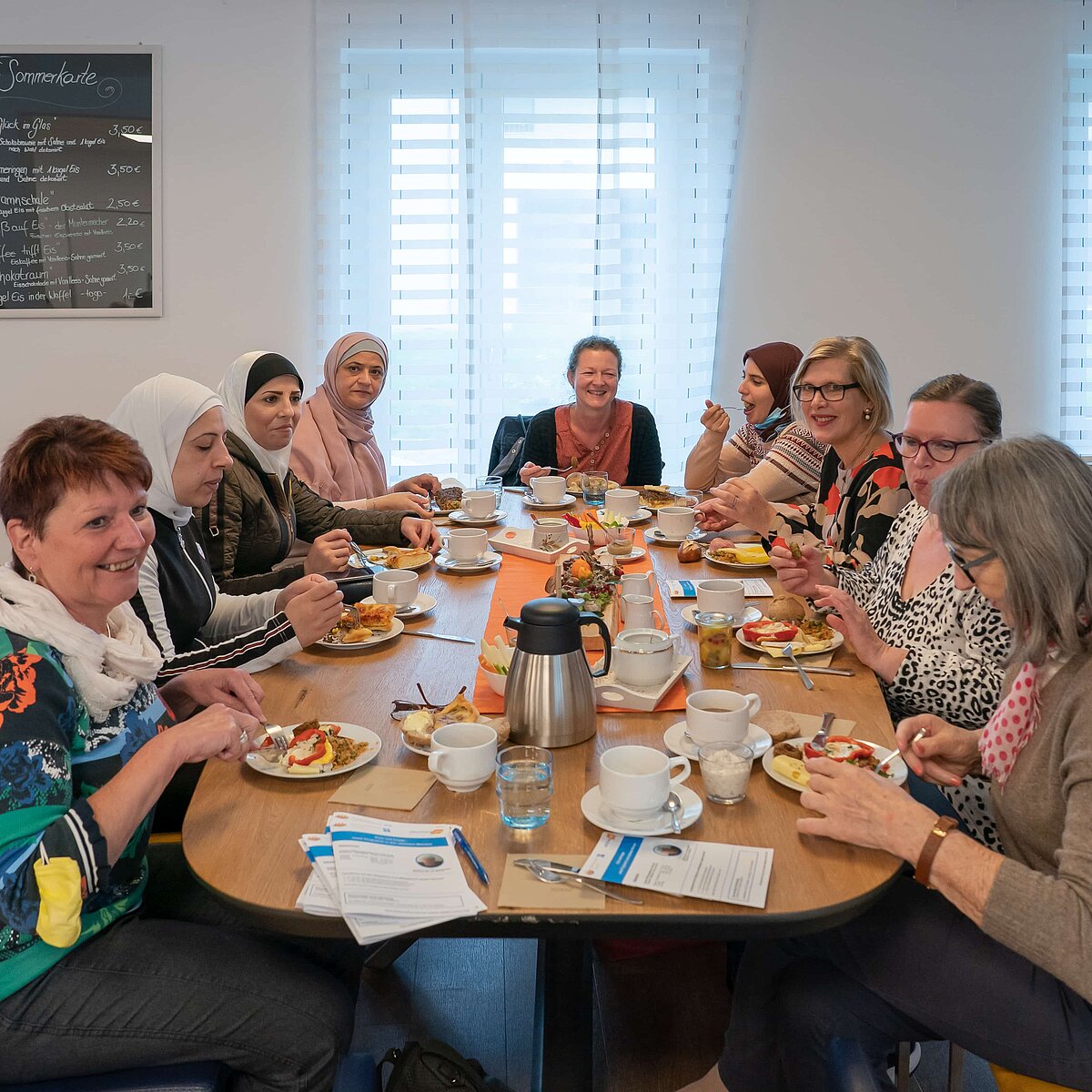 BMFSFJ Mehrere Frauen sitzen an einem Tisch und frühstücken