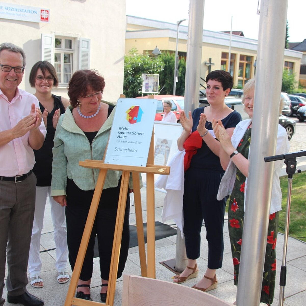 Staatssekretärin zeigt die Plakette bei der MGH Einweihung