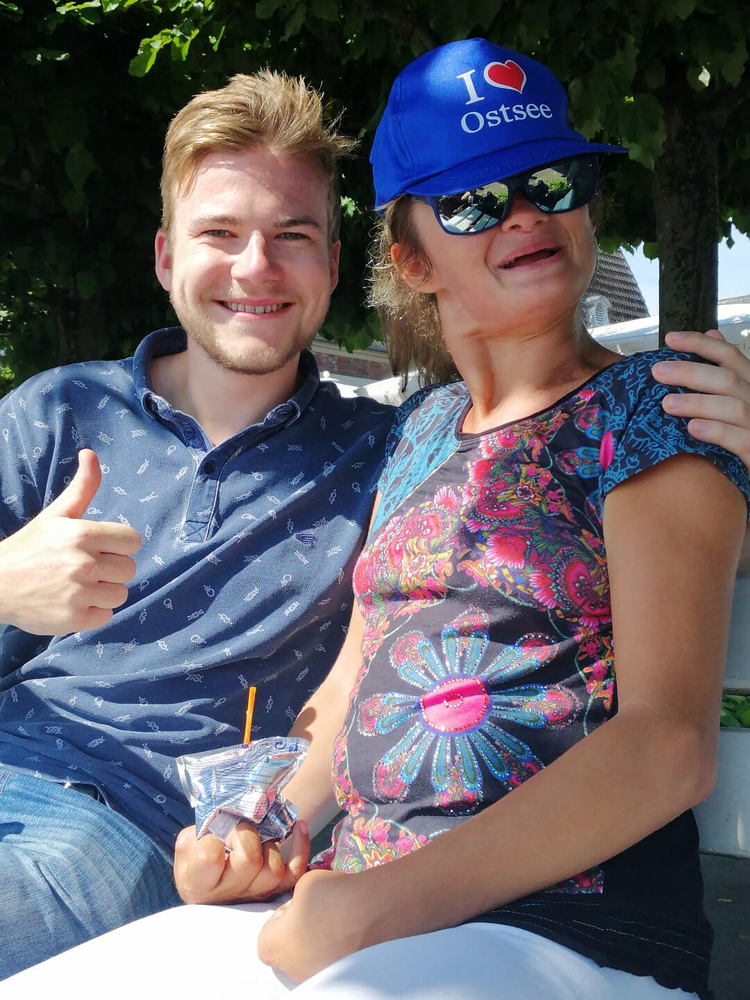 Foto von Jakob Ruch und einer Person mit blauer Kappe und Sonnenbrille.