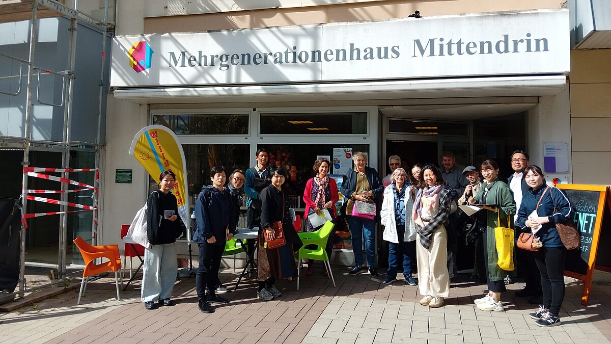 Die japanische Delegation steht vor dem Mehrgenerationenhaus