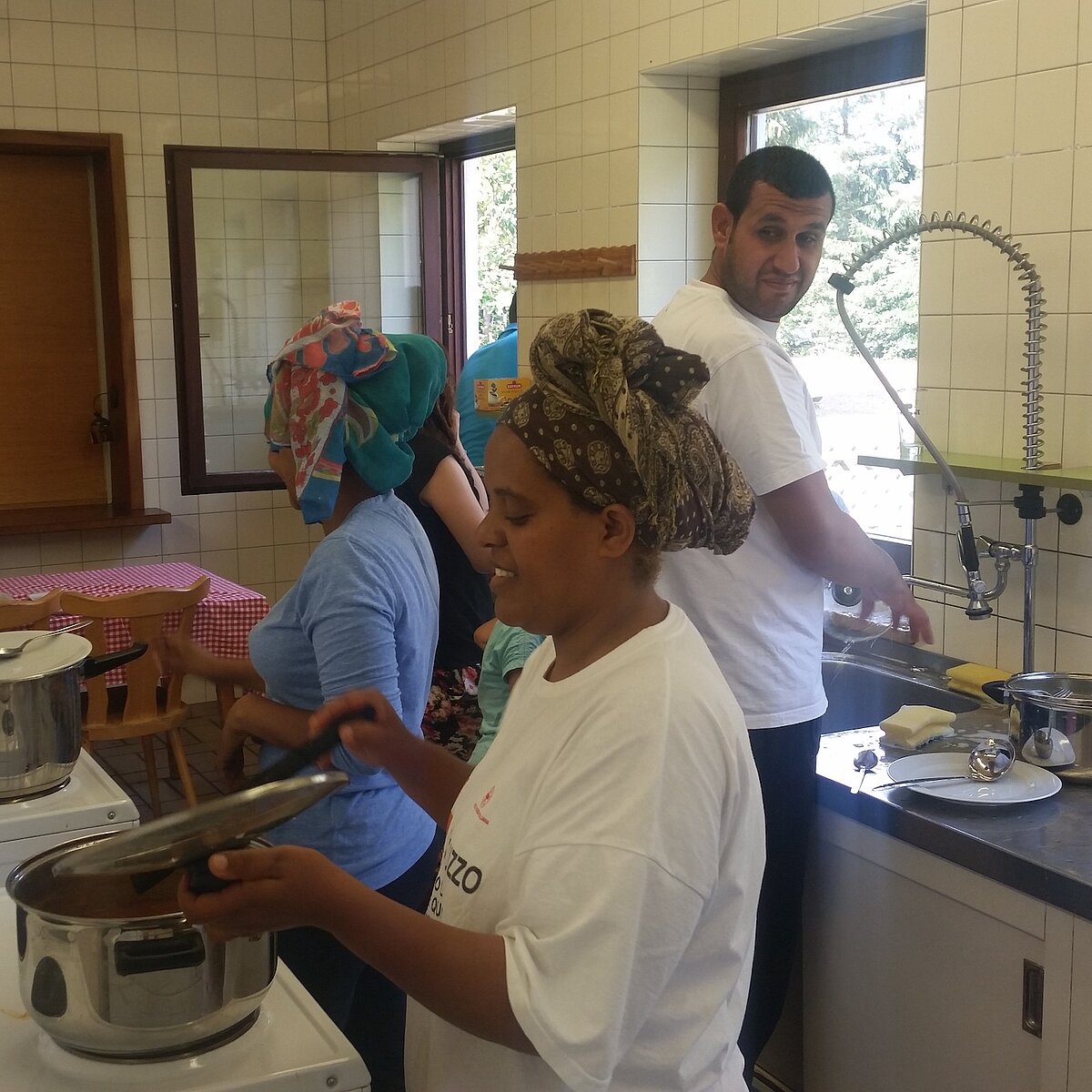 Besucherinnen und Besucher des MGH beim gemeinsamen Kochen.
