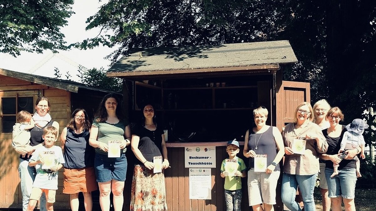 Erwachsene und Kinder stehen vor der "Tauschhütte"