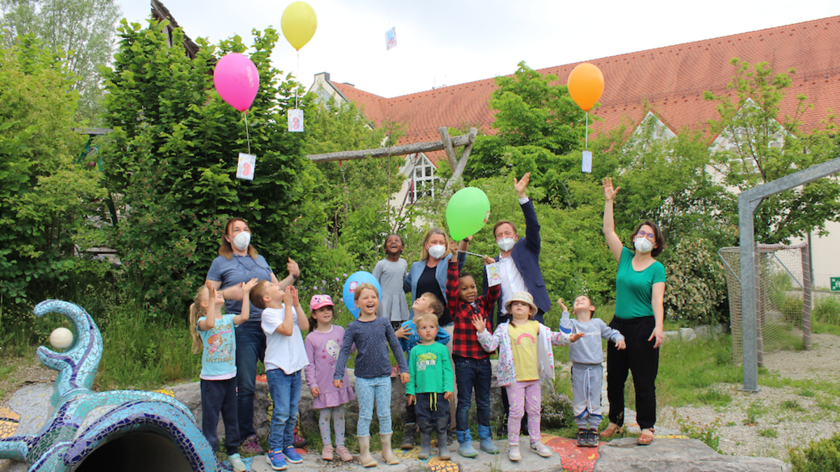 Neun Kinder und vier Frauen lassen Luftballons in die Luft steigen