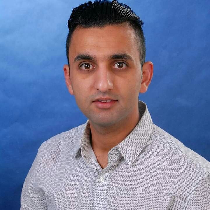 Ali Saoud Omer trägt ein Hemd. Er hat kurze, schwarze Haare und dunkle Augen.