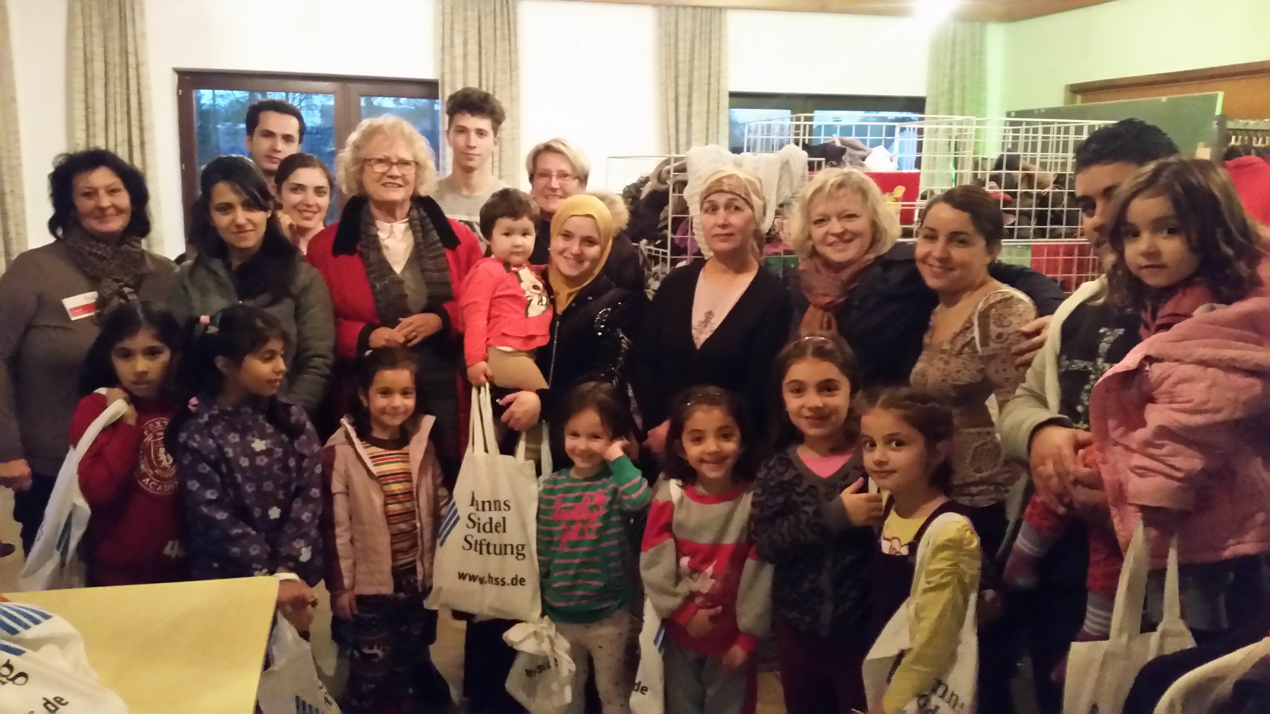 Bewohnerinnen des Tannenbergheims mit ihren Kindern bei einer Spendenübergabe, die von der Frauen-Union Rehau organisiert wird. Foto: MGH Rehau. Gruppenfoto mit rund zwanzig Personen. Einige sind geflüchtete Frauen mit kleinen Kindern.