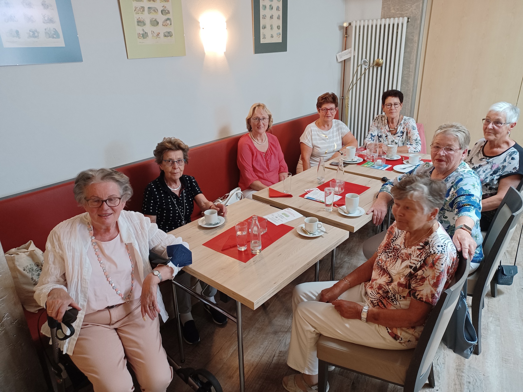 Acht ältere Damen sitzen an einem Tisch